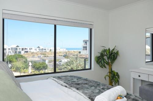 a living room with a large window with a view at sandytoesatbigbay in Cape Town