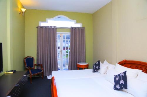 尼甘布Donald Mansion的一间带床、书桌和窗户的酒店房间