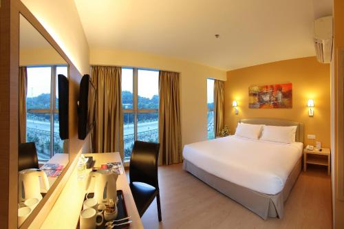 Habitación de hotel con cama, escritorio y ventana en Hotel Min Cott, en Kuala Lumpur