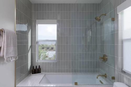 une salle de bain avec une baignoire et une fenêtre dans l'établissement Luxury Villa Pool & Spa Looking Glass, à Yucca Valley