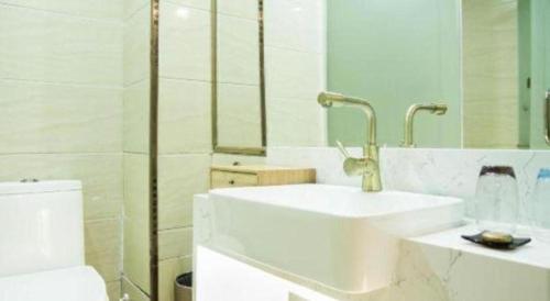 a white bathroom with a sink and a toilet at James Joyce Coffetel Baoding Railway Station in Baoding