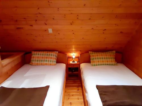 2 Betten in einem kleinen Zimmer mit Holzwänden in der Unterkunft seisen-ryo - Vacation STAY 95870 in Gujō