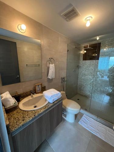 une salle de bain avec un lavabo, des toilettes et une douche dans l'établissement CoronadoWind, à Las Lajas