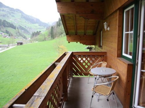 a balcony of a cabin with a table and chairs at Apartment in Grossarl near Ski Slopes in Grossarl
