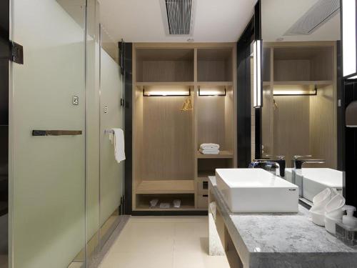 een badkamer met wastafel en douche bij Echarm Hotel Changsha Gaoqiao in Changsha