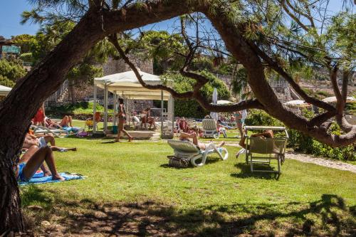 a group of people laying on the grass in a park at Hotel Calamosca in Cagliari