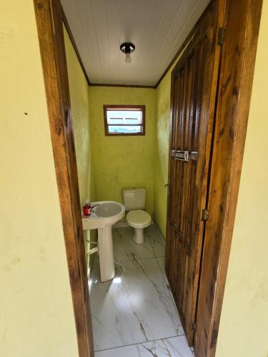 a bathroom with a toilet and a sink at Pousada Nonno Tranquilo - Chalé Sol, Lua, Estrela, Serra e Montanha in Lauro Müller