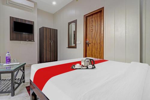 a bedroom with a bed and a table and a television at HOTEL O LAXMAN GRAND in Tapovan