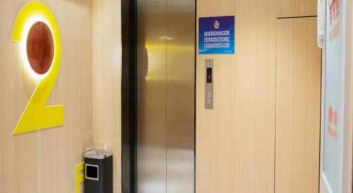 a elevator in a building with a sign on the wall at IU Hotels Beijing Changping Bei Qijia in Changping