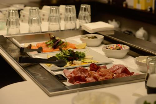 a buffet line with different types of food on plates at Hôtel & Appartements Monsigny in Nice