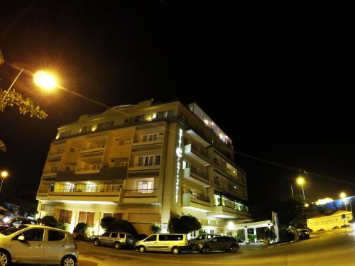 a building with cars parked in front of it at night at Hotel Continental Luanda in Luanda