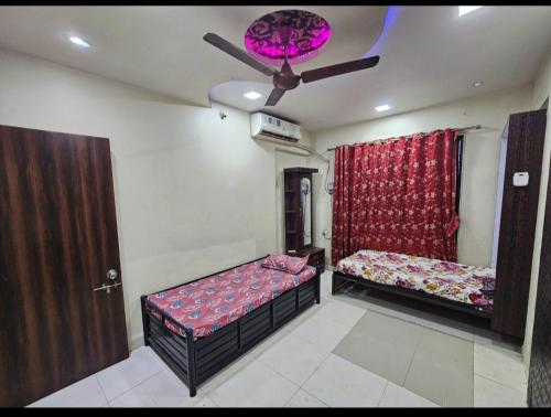 a bedroom with two beds and a ceiling fan at Ac Bed with breakfast At ovale naka ghodbunder road thane west in Thane