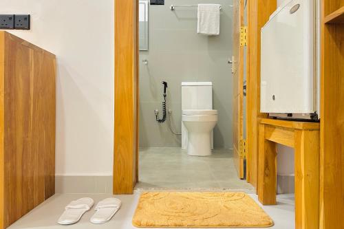 a bathroom with a toilet and a shower and a rug at Gamagedara Resort in Dambulla