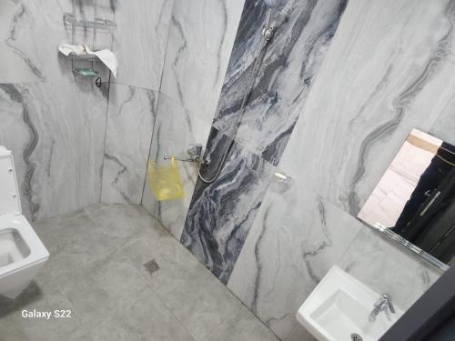 a marble bathroom with a sink and a toilet at Ramalin evi in Quba