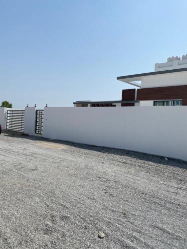 een witte muur naast een gebouw bij Relax Home in Barka