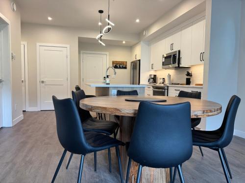 a kitchen and dining room with a wooden table and chairs at Paradise Point - Hot Tub & Mountain Views in Golden