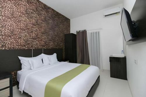 Una habitación de hotel con una cama y un televisor. en Arotel BSD, en Tangerang