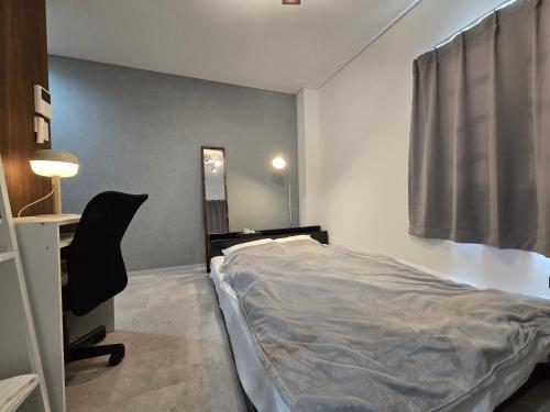 a bedroom with a bed and a desk and a chair at SABBATH uzumaza 103 in Kyoto