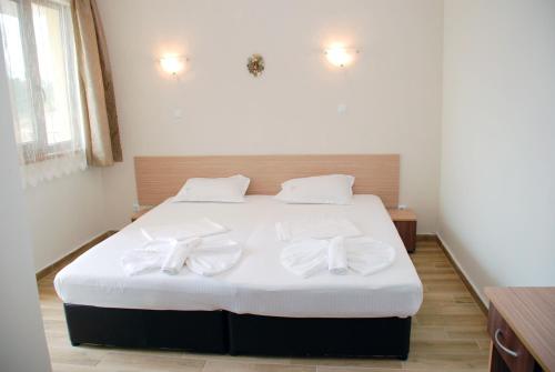 ein Schlafzimmer mit einem Bett, das mit weißen Schleifen verziert ist in der Unterkunft Altay Guest House in Lozenets