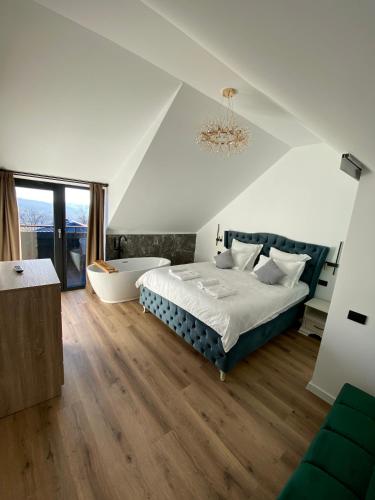 ein Schlafzimmer mit einem großen Bett und einer Badewanne in der Unterkunft EleS Chalet in Brebu