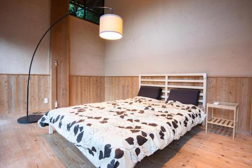 a bedroom with a cow print bed with a lamp at 山小屋吉丁 in Ukiha
