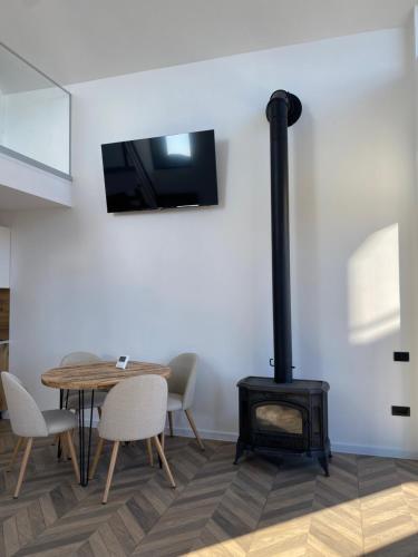 Zimmer mit einem Tisch und einem Holzofen in der Unterkunft EleS Chalet in Brebu