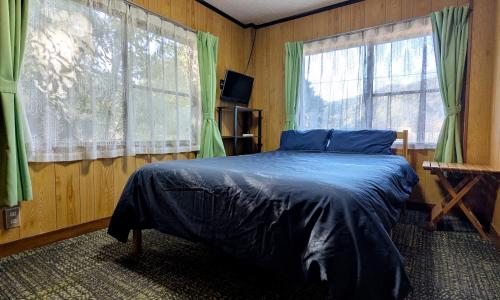 um quarto com uma cama e duas janelas em 伊根の宿 汐風 Shiokaze em Nomuro