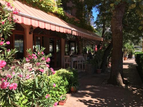 a restaurant with pink flowers and a tree at Oleander House and Tennis Club in Sunny Beach