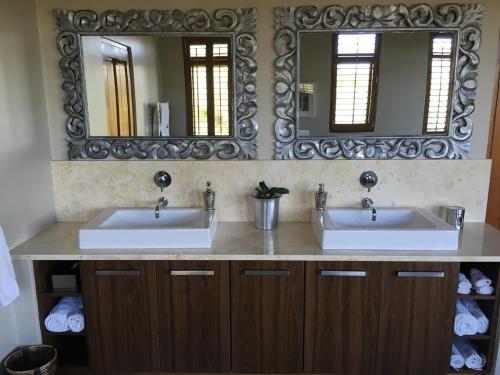 a bathroom with two sinks and a mirror at Plettenberg Bay Getaway in Plettenberg Bay