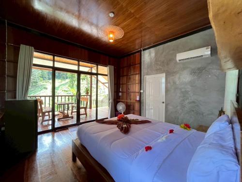 une chambre avec un grand lit blanc et un balcon dans l'établissement Koh Jum Serenity Resort, à Ko Jum