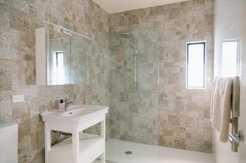 a bathroom with a sink and a shower at Sunny and Modern Nelson Retreat with Designer Kitchen in Nelson