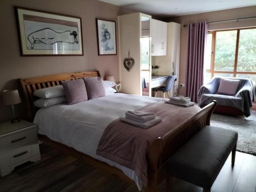 une chambre avec un grand lit et une chaise dans l'établissement Stylish 4 bedroom house By The Sea, à Wexford