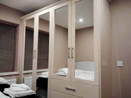 une chambre avec une armoire blanche avec un miroir dans l'établissement Stylish 4 bedroom house By The Sea, à Wexford