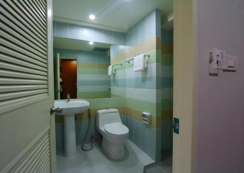 a bathroom with a toilet and a sink at Prosperous in Hat Yai