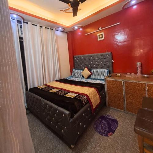 a bedroom with a black bed with a red wall at Hotel The Deep Presidency in Jāmb