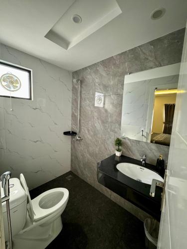 a bathroom with a white toilet and a sink at Dazzy Dream Guest Houses in Islamabad