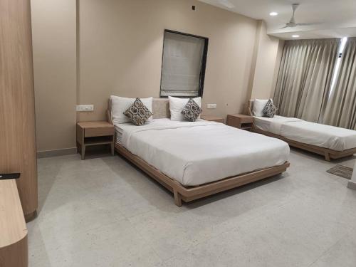 a bedroom with a large bed and two tables at Hotel Sun Shine in Jāmb