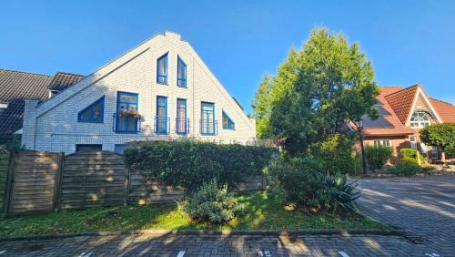 a white house with a fence in front of it at Am Obstgarten in Hinte
