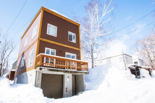 a house with a balcony in the snow at Yukisawa House in Kutchan