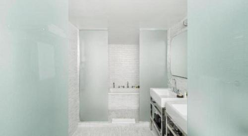 a white bathroom with two sinks and a mirror at COMO Metropolitan Miami Beach in Miami Beach