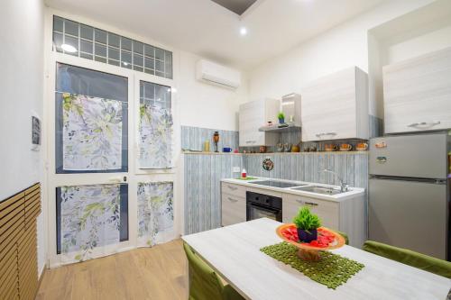 a kitchen with white cabinets and a table with a bowl on it at villa del mare in Nettuno