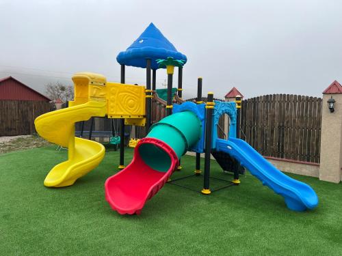 un parque infantil con un tobogán en el césped en SEAR Ailəvi Məkan, en Qusar
