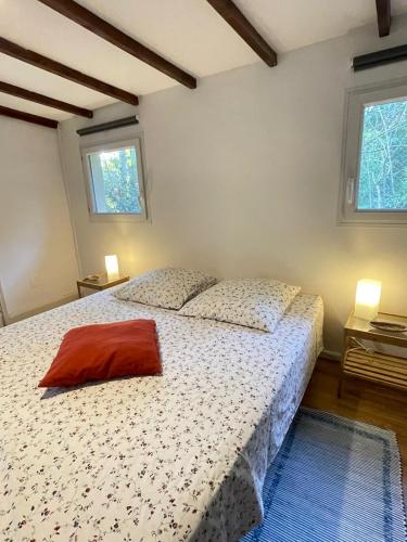a bedroom with a bed and two windows at Charmant Mazet en campagne provencale in Châteaurenard
