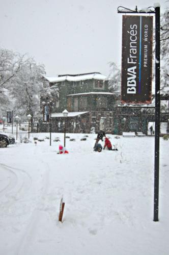 a group of people sitting in the snow at Departamentos de El Mercado in Villa La Angostura