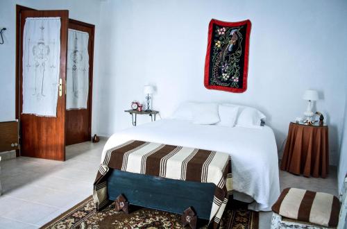 a bedroom with a large white bed and a door at Os 5 Sentidos in Mourão