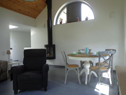 a dining room with a table and a chair at B&B Domaine du Vieux Chêne in Stoumont