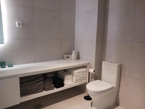 un bagno con lavandino, WC e asciugamani di Lagoa Princess Condo a Lagoa