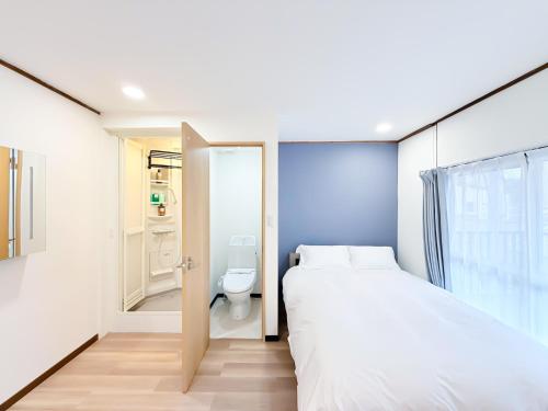 a small bedroom with a bed and a toilet at Osaka Large House 13Guests 5BR 3Bath 3Shower in Osaka