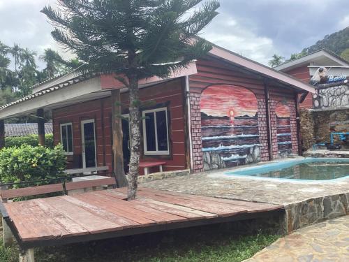 ein Haus mit einer Palme vor einem Pool in der Unterkunft Baan Saitharn Koh Lanta in Ban Not (1)