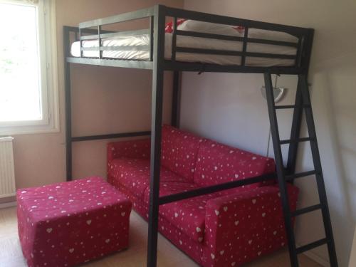 a bunk bed with a red couch and a chair at Bois d'Aurouze SuperDévoluy in Les Cypières